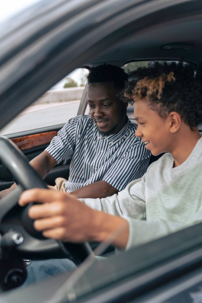 pexels-photo-9518021 Father and teenage son sitting in a car, bonding while learning to drive.